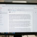 Capture éditoriale documentaire d’un écran d’ordinateur montrant une interface de page en ligne avec un onglet historique bien visible, éclairage sobre et couleurs gris neutres.