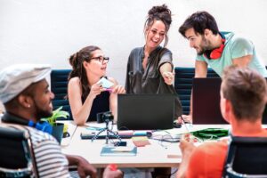 Créatrice de contenu échangeant avec une équipe d’agence autour d’un ordinateur portable.